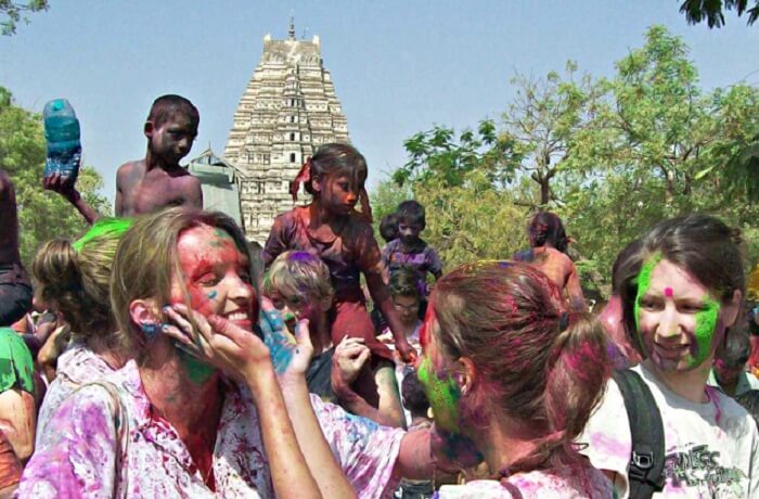 Foreign tourists enjoying applying colors at each other during holi celebrations at Hampi