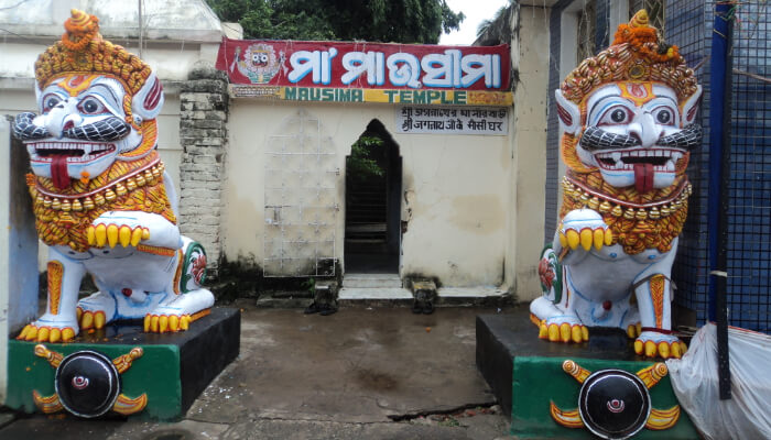 A glorious view of a striking entrance guarded by two statues on the sides of Mausima Temple in Puri